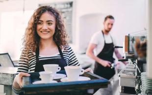 Waitress carrying a tray of coffee cups