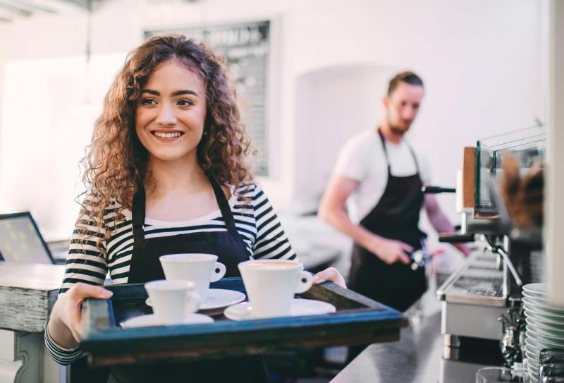 Waitress carrying a tray of coffee cups