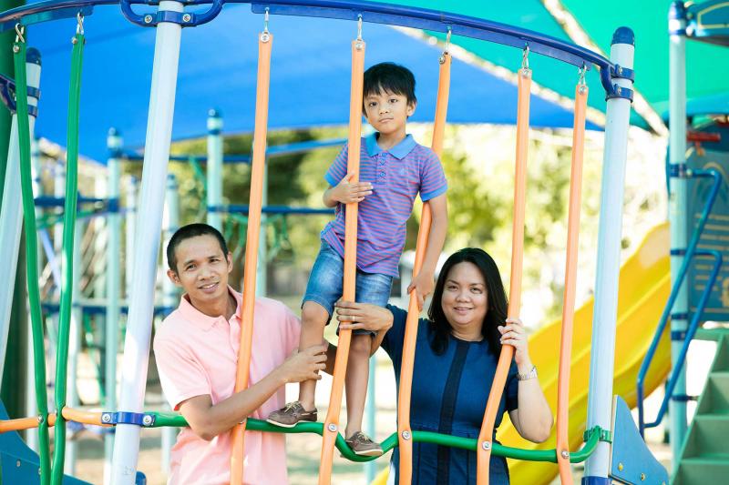 Young migrant family in children's playground