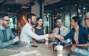 Business people shaking hands at a meeting table