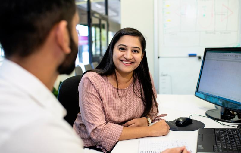 Woman and man in the office at desk in front of computer