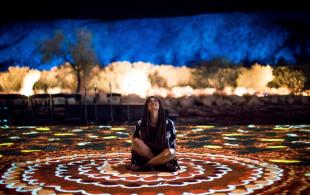 Lading sitting on the ground at the Parrtjima - night light festival