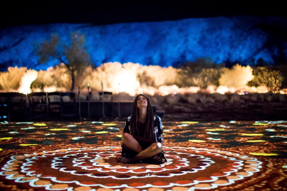 Lading sitting on the ground at the Parrtjima - night light festival