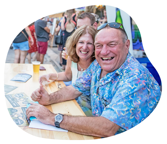 Middle aged couple smiling whilst having a beer